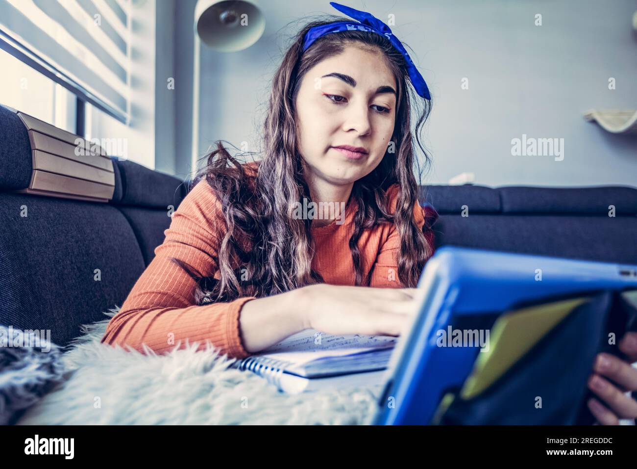 Grand angle sur la femme étudiante prenant des notes dans le cahier de la tablette Banque D'Images