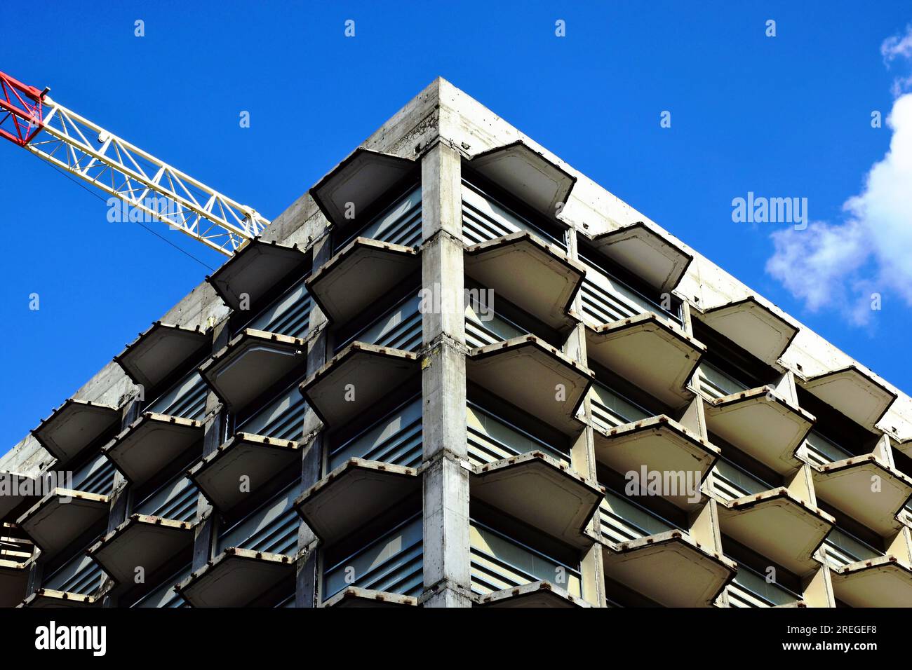 coin de construction en béton. structure de charpente d'hôtel à plusieurs étages en construction. flèche de grue à tour en acier blanche et rouge. Banque D'Images