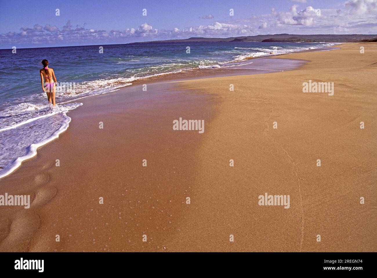 Un touriste se promène le long de la magnifique plage immaculée de Papohaku, à l'ouest de Molokai, l'une des plus longues et des plus belles plages des îles hawaïennes. Banque D'Images