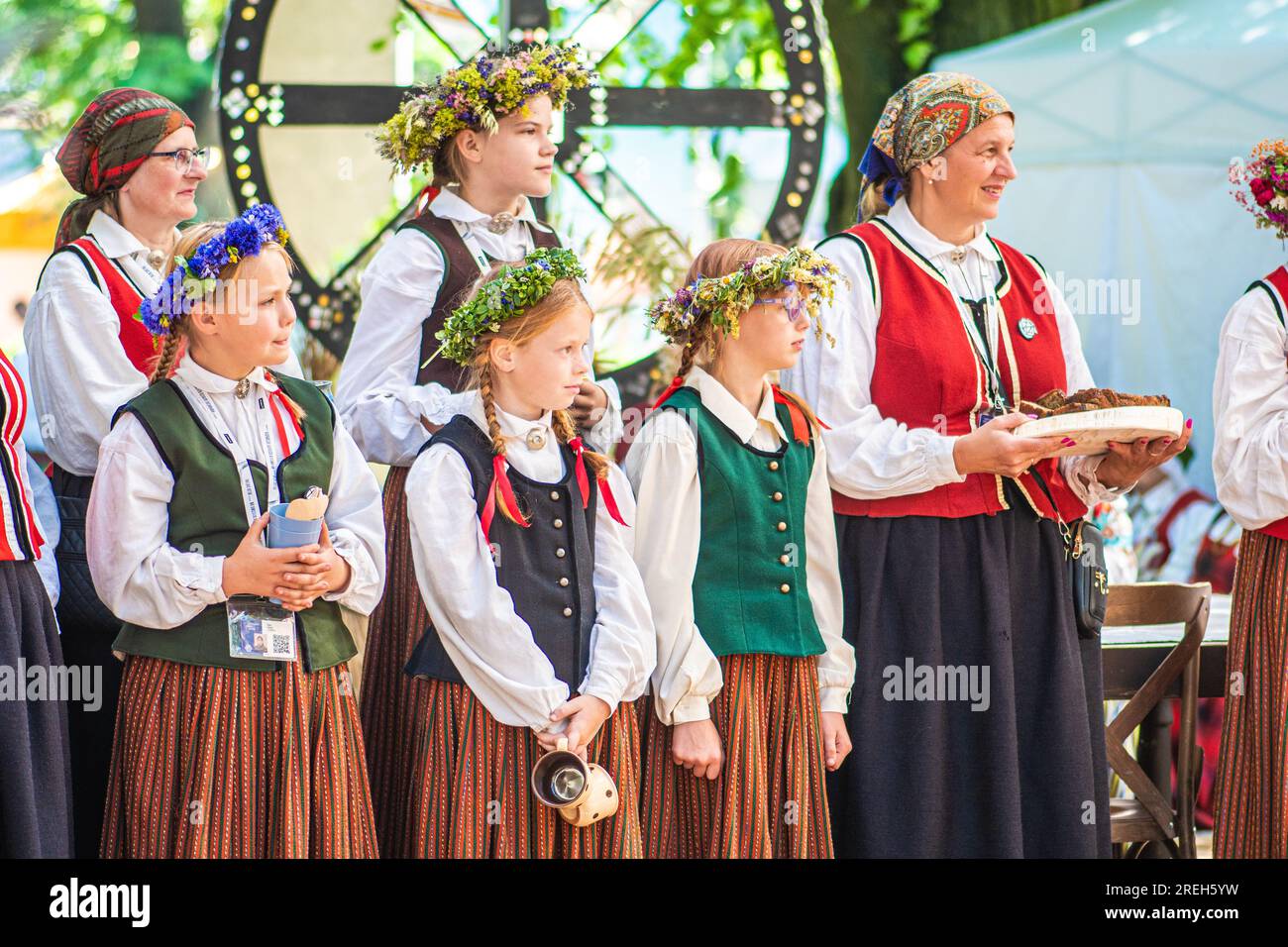 Groupe d'adultes et d'enfants en vêtements traditionnels jouant et chantant sur la scène pendant XXVII Festival national de chanson lettone et XVII Dance Banque D'Images