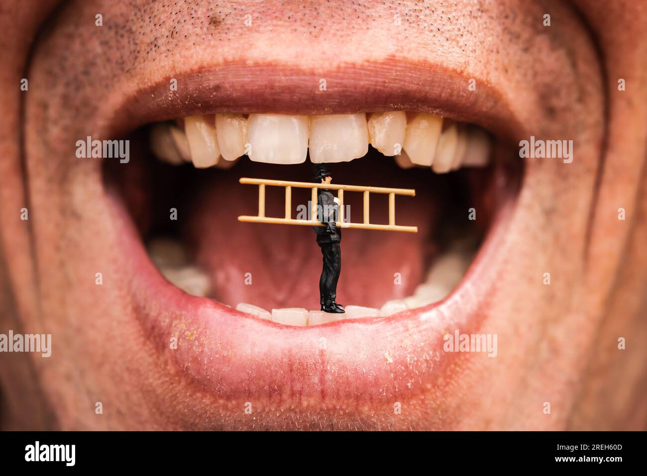 Concept d'hygiène dentaire réparateur miniature ou concierge avec escabeau debout à l'intérieur de la bouche d'un homme prêt à nettoyer les dents Banque D'Images