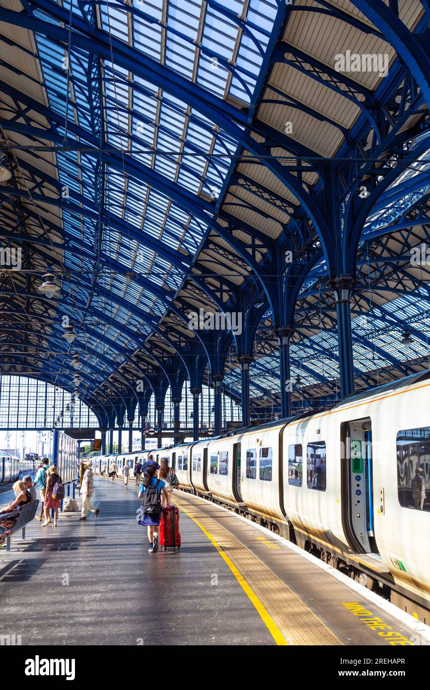 Les gens marchent le long de la plate-forme à Brighton Station, Brighton, East Sussex, Angleterre Banque D'Images