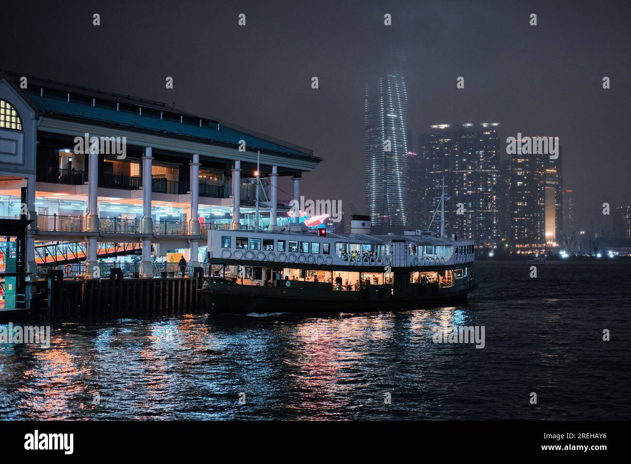 Hong Kong, Chine - 24 avril 2023 : vue de nuit du « Star ferry » à l'embarcadère et des personnes embarquant Banque D'Images