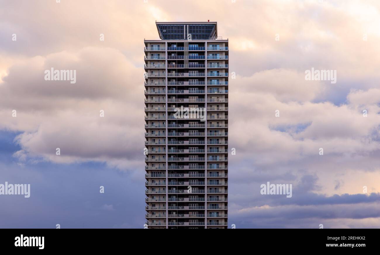 Nuages bleus et roses derrière le grand immeuble après le coucher du soleil Banque D'Images