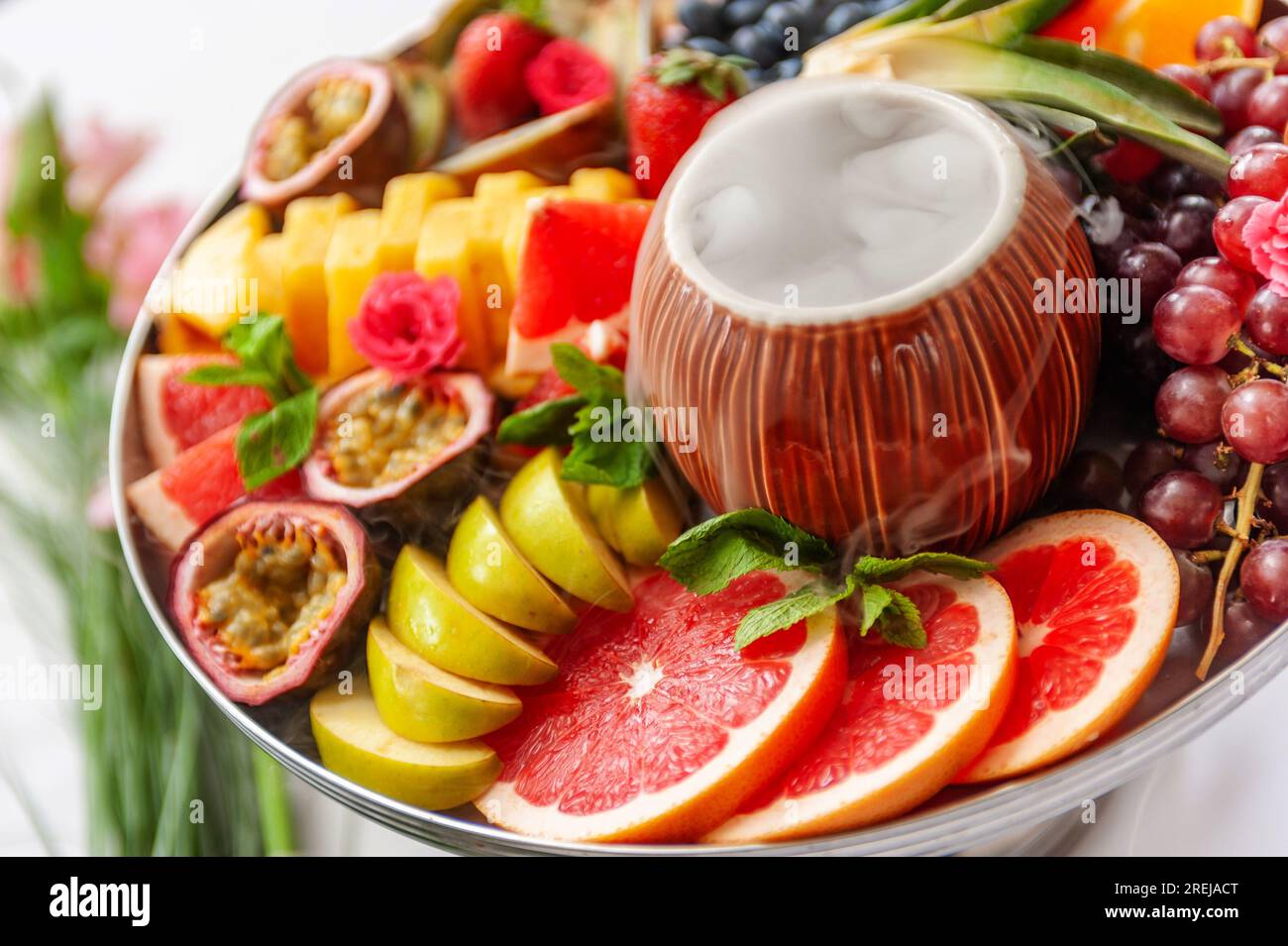 Assortiment de fruits crus et de baies sur l'assiette, sur la table blanche Banque D'Images