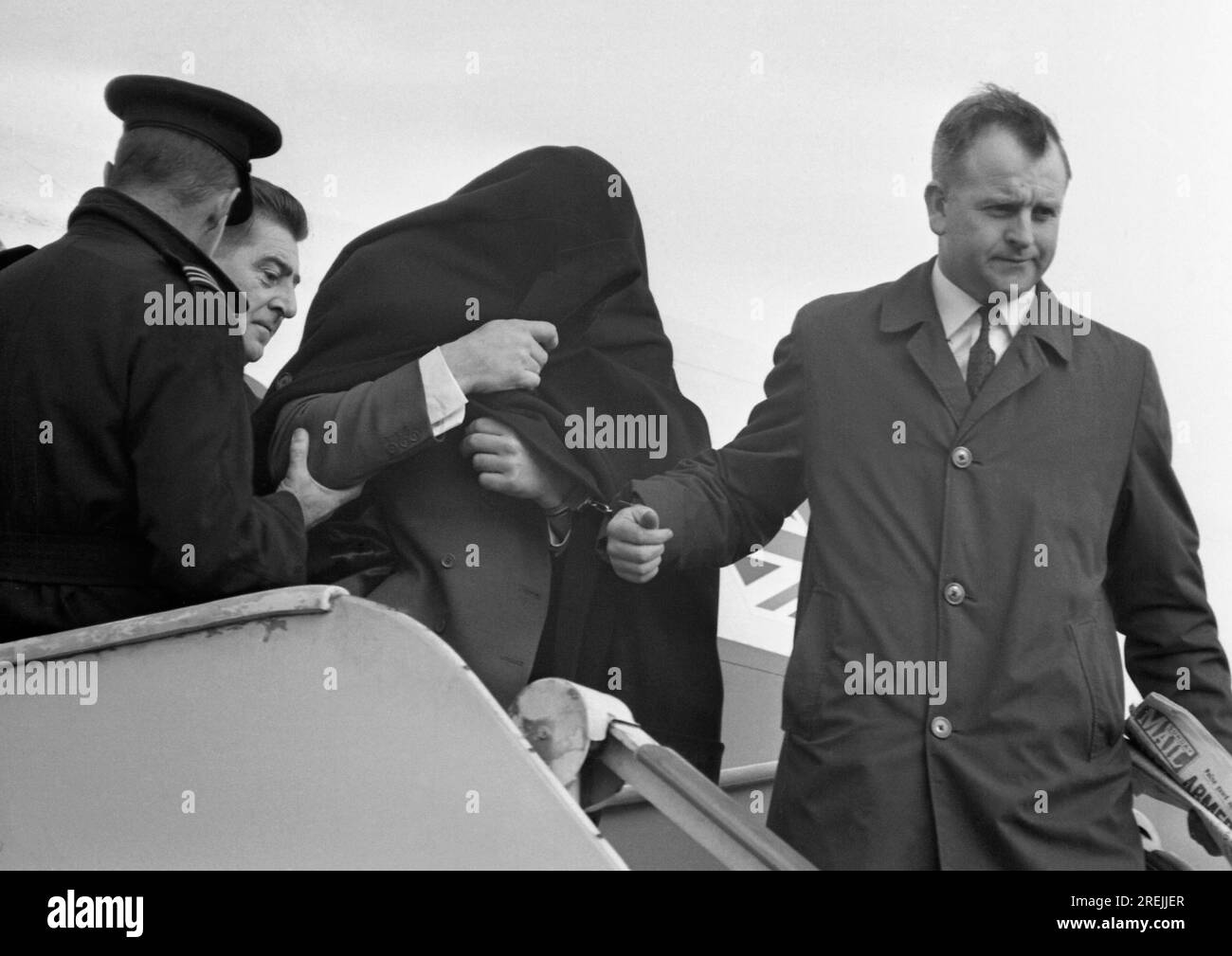 Head covered in an overcoat, great train robber Charles Wilson, 37, is