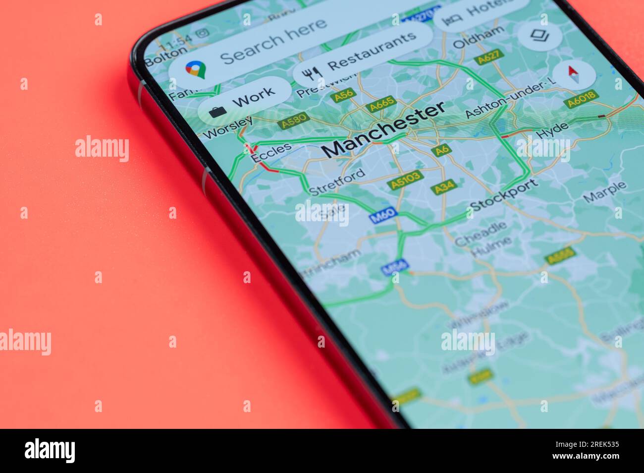 New York, USA - 21 juillet 2023 : carte des embouteillages à Manchester sur écran smartphone vue rapprochée avec fond rouge Banque D'Images