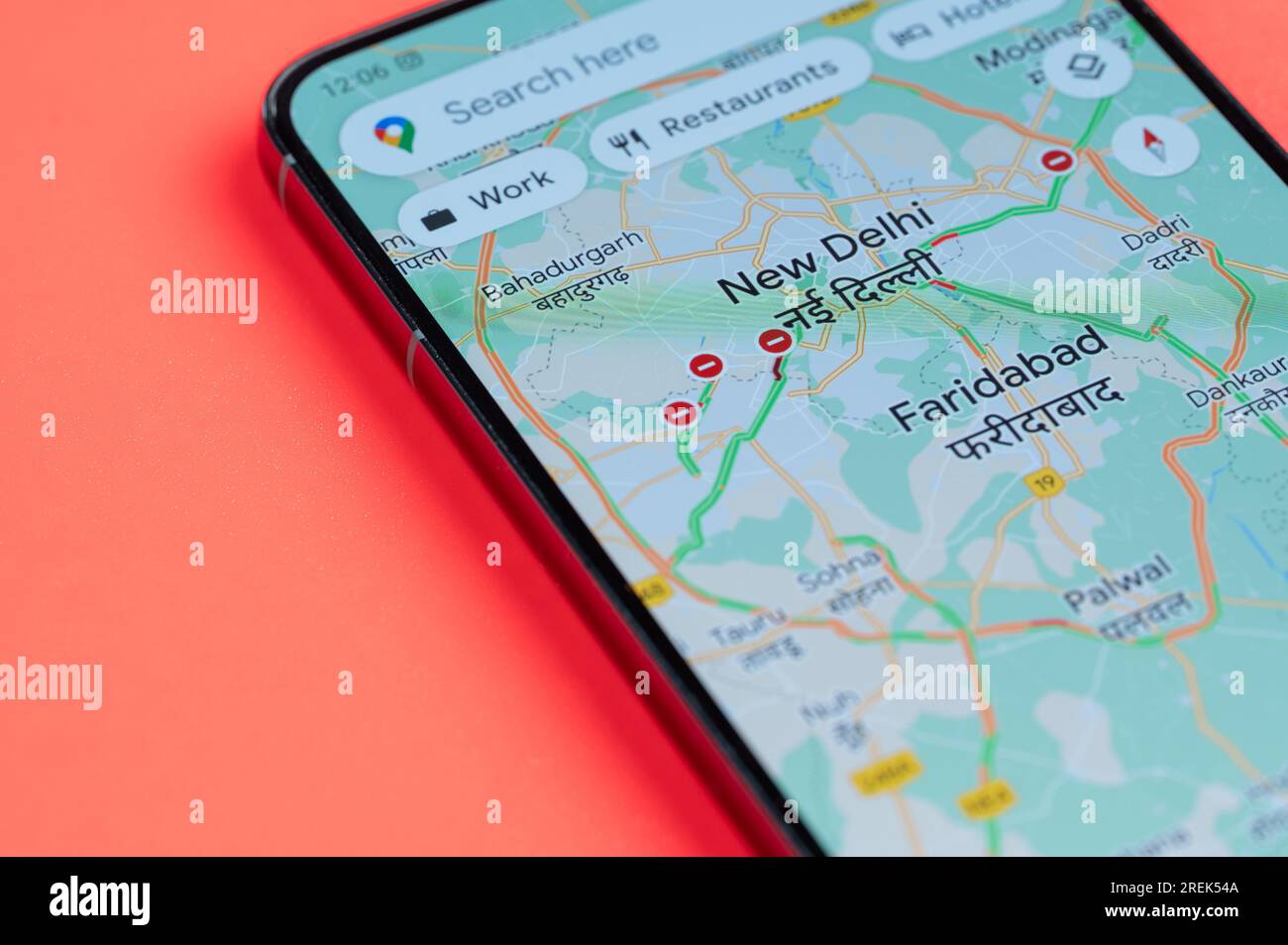 New York, États-Unis - 21 juillet 2023 : New Delhi distribution du trafic automobile dans google maps sur écran smartphone vue rapprochée avec fond rouge Banque D'Images