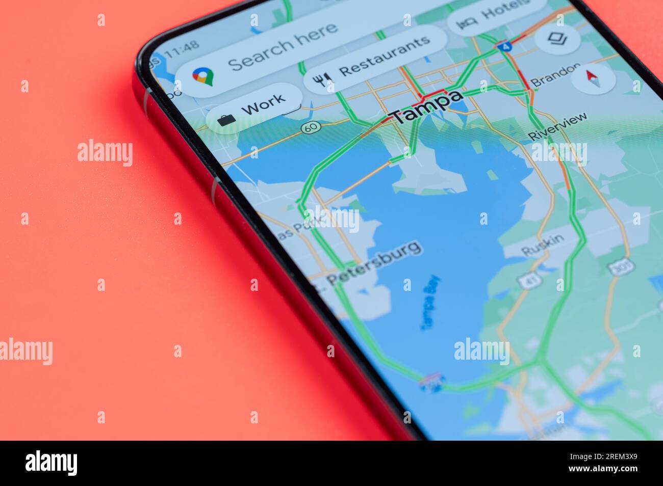 New York, États-Unis - 21 juillet 2023 : trafic automobile sur Tampa google Maps sur écran smartphone vue rapprochée avec fond rouge Banque D'Images