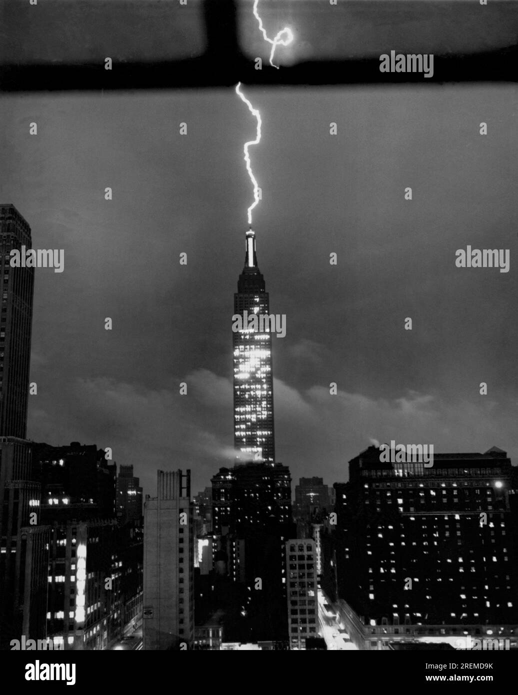 New York, New York : 9 juillet 1945. Alors que la ville est frappée par une tempête soudaine d'été, une série de foudre déchiquetée se précipite dans le ciel pour s'installer sur la pointe du dôme de l'Empire State Building de New York, au-dessus des rues de Manhattan. Banque D'Images