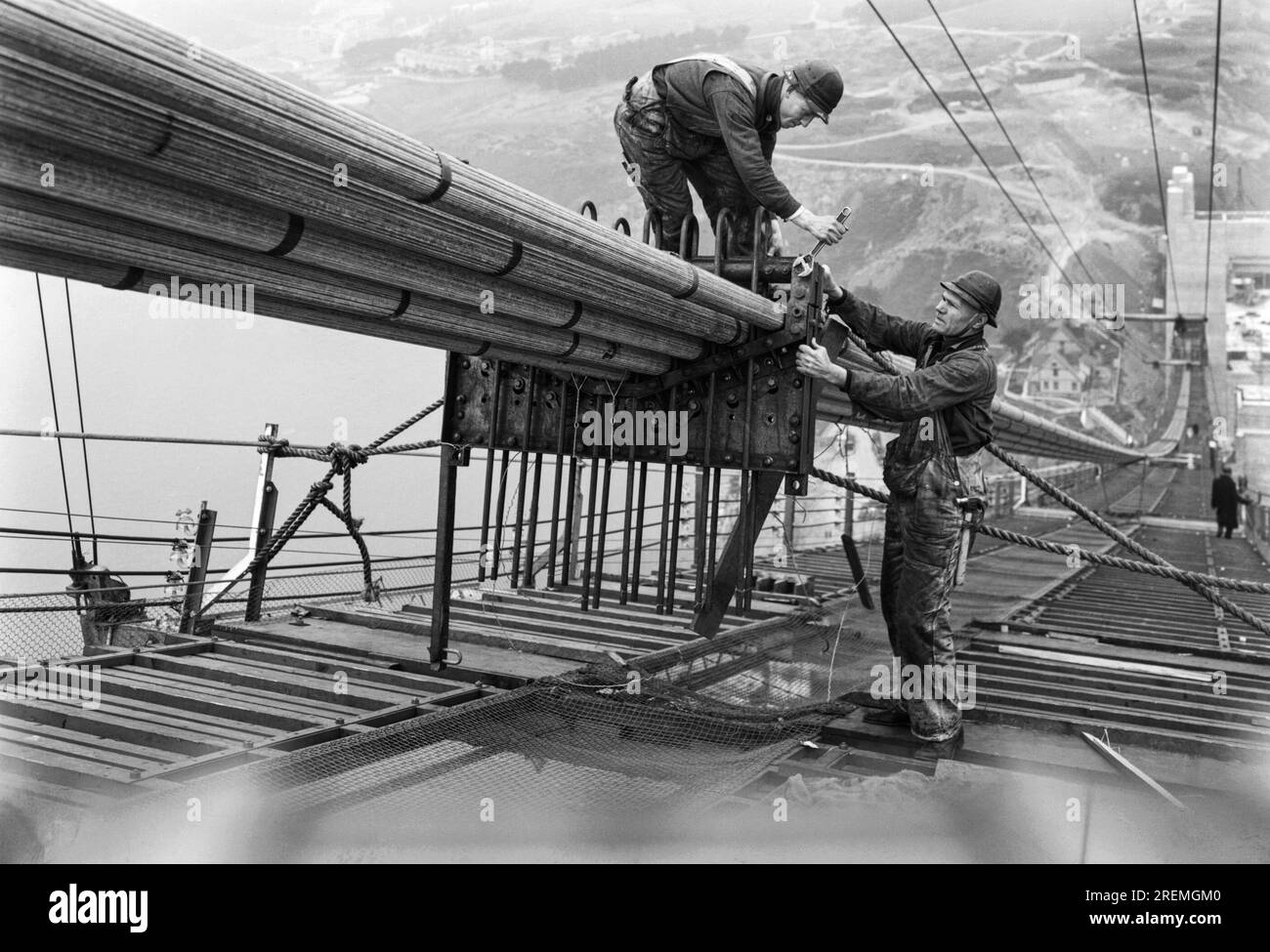 San Francisco, Californie : c. 1936 travailleurs sur les passerelles rassemblant les câbles pendant la construction des câbles du Golden Gate Bridge. Banque D'Images