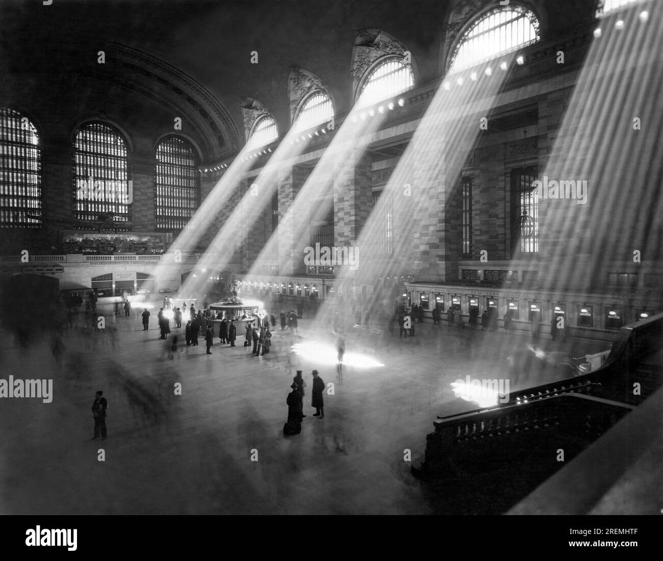 New York, New York : c. 1940's. Une vue intérieure de la gare ferroviaire Grand Central, avec la lumière du soleil affluant à travers les fenêtres du clergé au-dessus. Banque D'Images