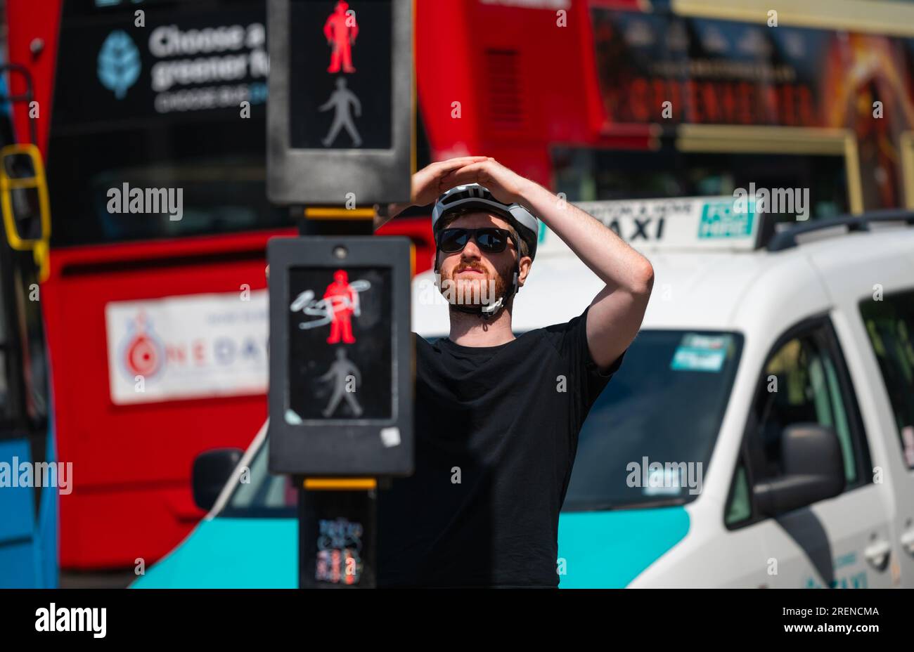 Cycliste à vélo, arrêté aux feux rouges, obéissant au Code de la route et aux règles de la route dans une ville animée en Angleterre, Royaume-Uni. Banque D'Images