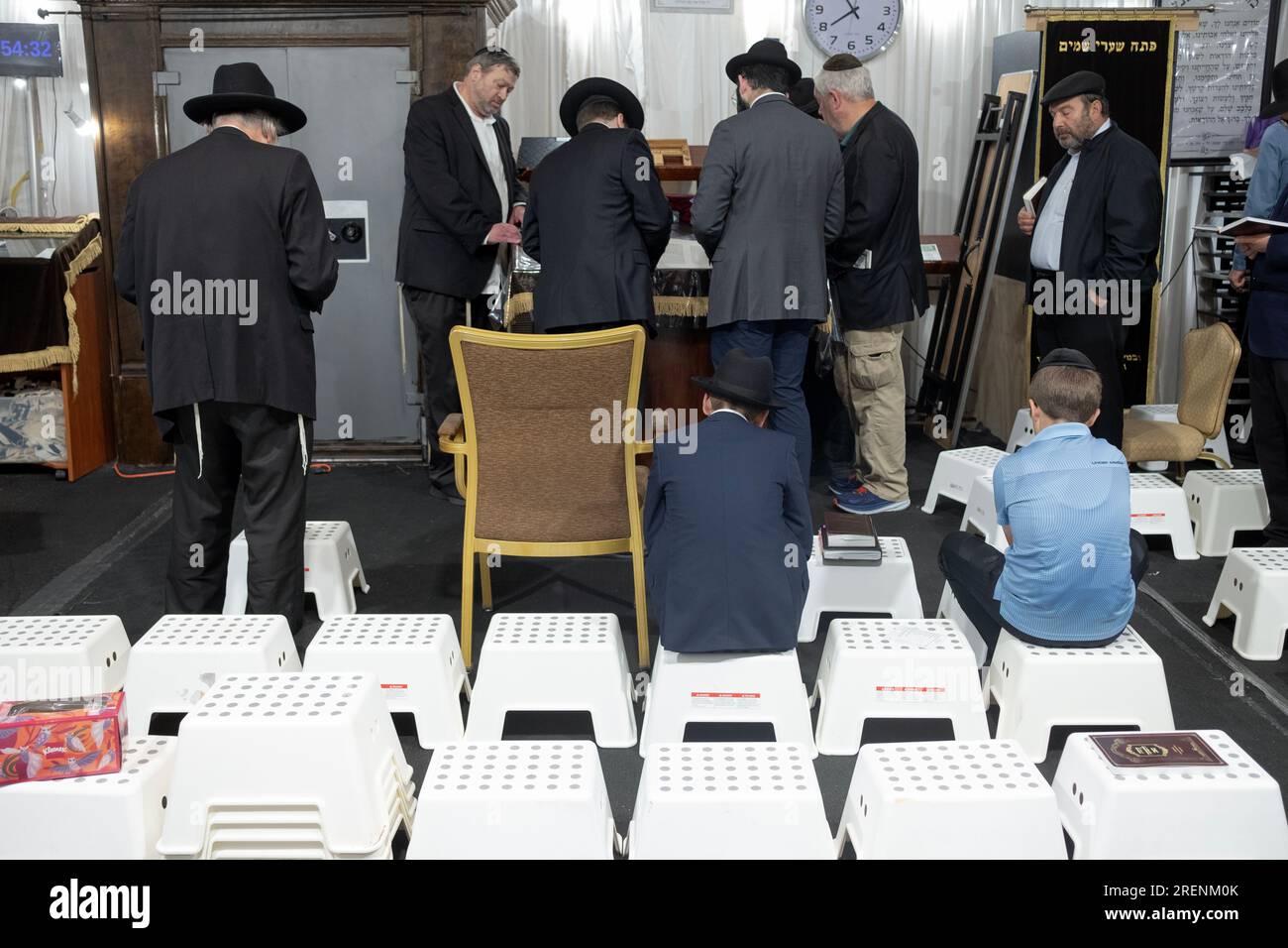 La lecture de la Torah à Tisha B'AV services matinaux où les rituels de deuil sont suivis, y compris en utilisant des sièges abaissés. A Monsey, New York. Banque D'Images