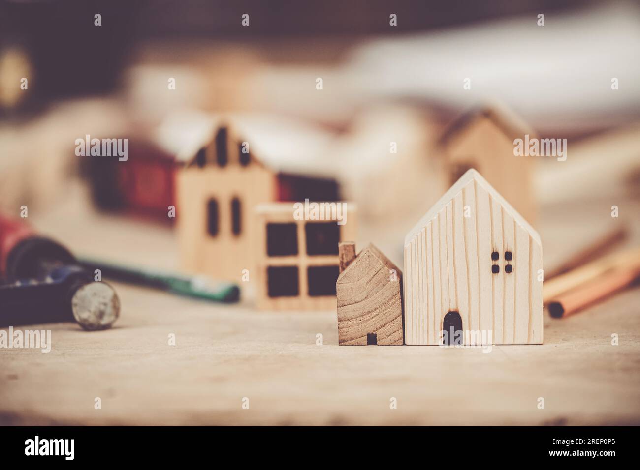petite et grande maison en bois sur la table de constructeur avec des outils pour construire un nouveau concept de comparaison de taille d'échelle de maison. Banque D'Images