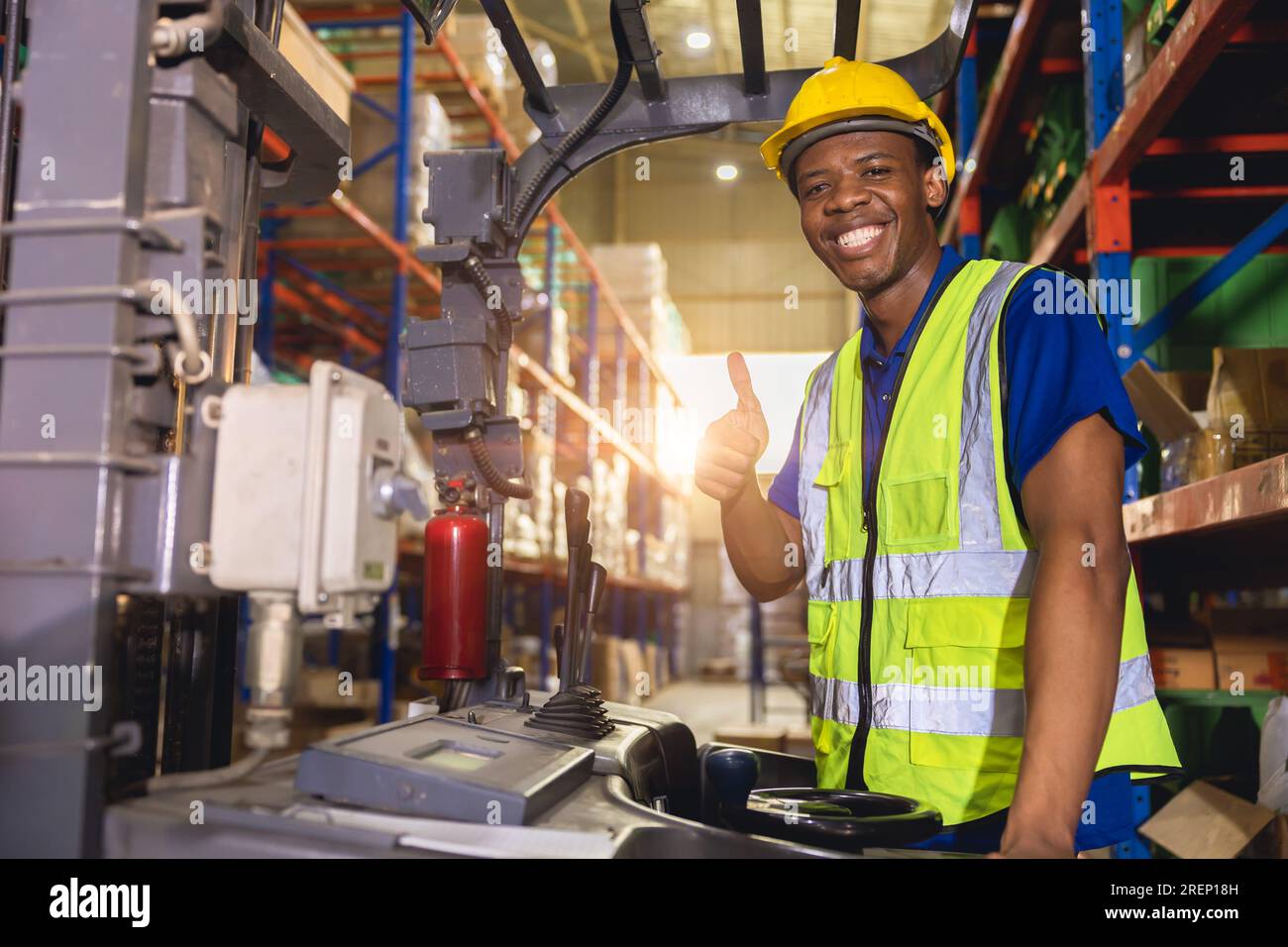 Travailleur noir africain heureux de travail de contrôle de chargement de cargaison de chariot élévateur dans le personnel d'employé d'industrie de logistique d'inventaire d'entrepôt Banque D'Images