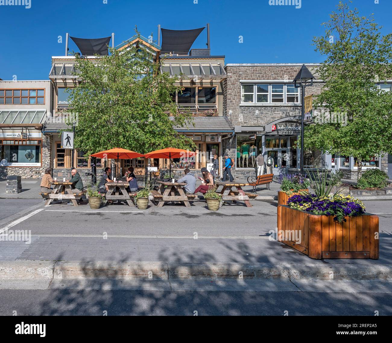 Banff, Alberta, Canada – 27 juillet 2023 : les gens mangent à des tables de pique-nique sur l’avenue Banff Banque D'Images