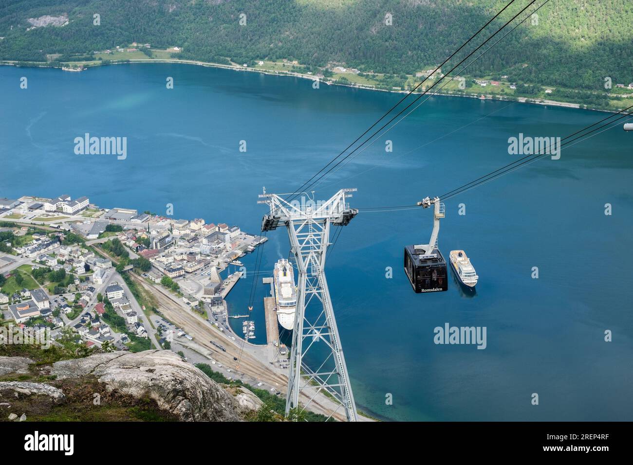Téléphérique Romsdalgondolen descendant de la montagne Nesaksla avec 2 bateaux de croisière dans le port par la ville ci-dessous. Andalsnes, Møre og Romsdal, Norvège Banque D'Images