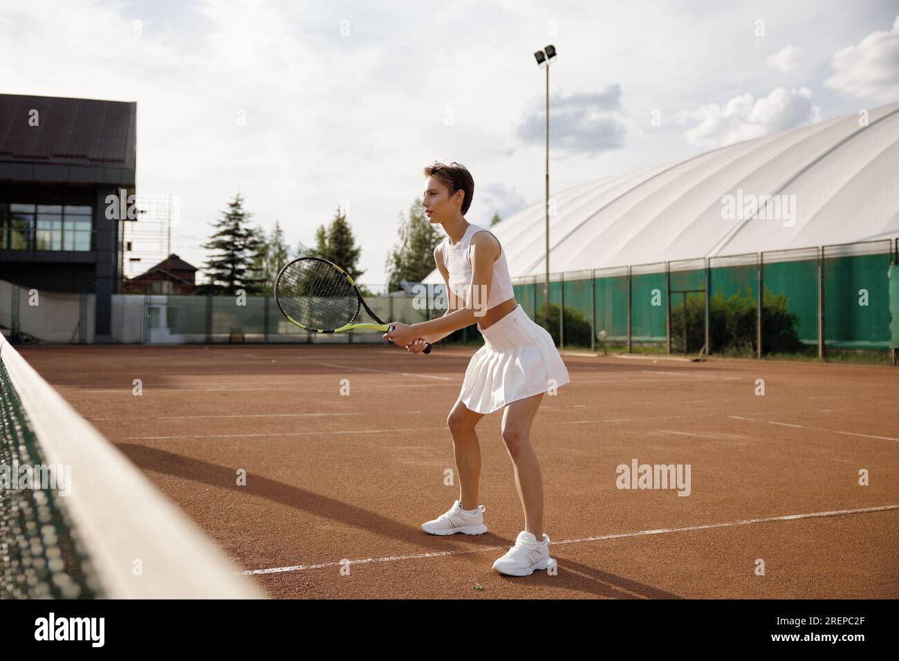 Vue latérale d'une joueuse de tennis en confiance tenant une raquette Banque D'Images