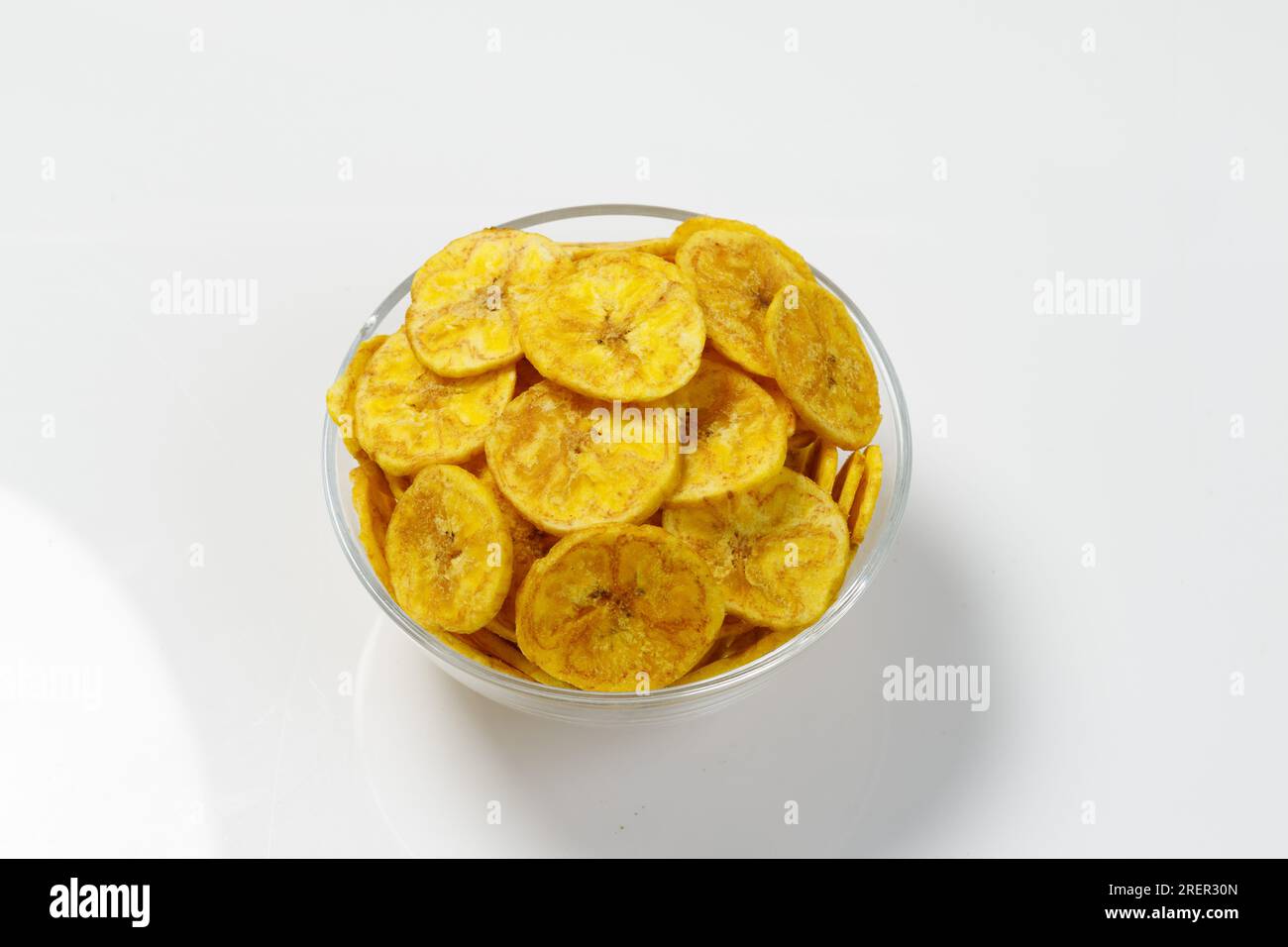 Kerala Chips ou Banana Chips, article culte de collation du Kerala, disposé dans un bol atransparent ; image isolée avec fond blanc Banque D'Images