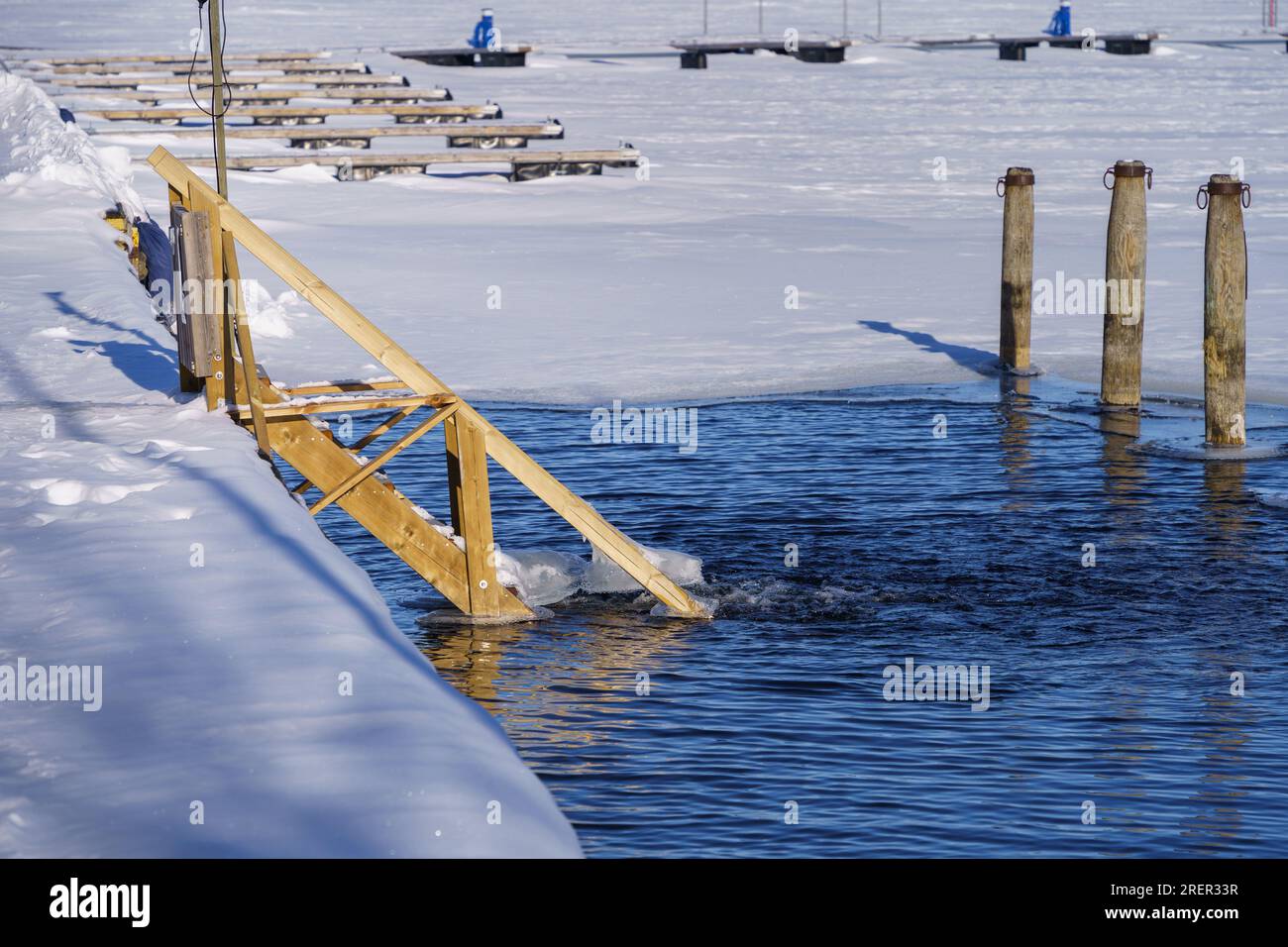 Baignade hivernale, escalier en bois menant à l'eau à Vaaksy, Asikkala, Finlande. Banque D'Images