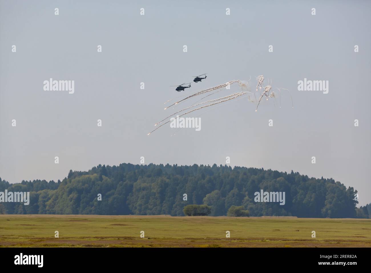 hélicoptères militaires échappant à la défense aérienne. Un hélicoptère libère des pièges thermiques pour échapper à un missile de défense aérienne. Aviation militaire sur une sortie de combat Banque D'Images