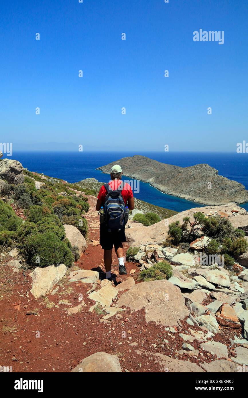 Walker sur le chemin de Livadia à la plage de Lethra le long du sentier de montagne rocheux, île de Tilos, groupe d'îles du Dodécanèse. Grèce, juillet 2023 Banque D'Images