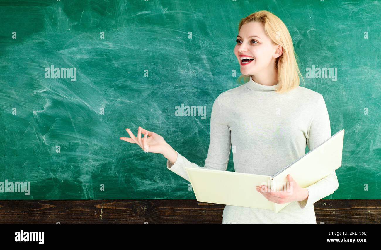 Enseignante souriante près du tableau dans la salle de classe de l'école. Enseignant donnant des leçons aux étudiants à l'école ou à l'université. Fille ou femme étudiante à l'université Banque D'Images