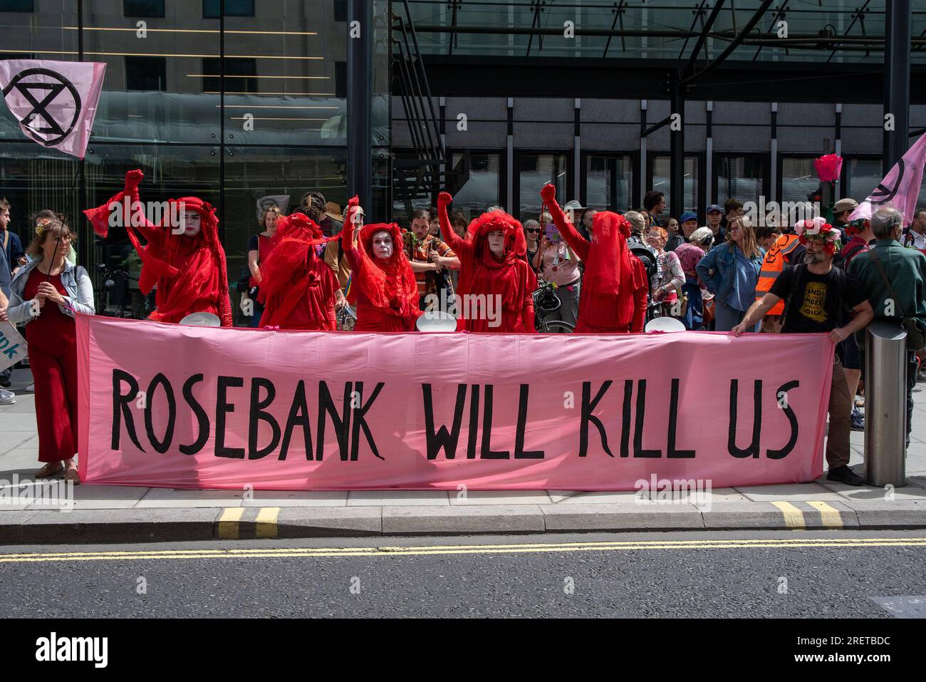 Des membres des rebelles rouges font des gestes en se tenant à côté d'une bannière exprimant leur opinion pendant la manifestation. Rosebank est le plus grand champ pétrolier et gazier non développé du Royaume-Uni avec un total de près de 500 millions de barils de pétrole. L'exploitant de la Rosebank est l'Equinor, une multinationale d'énergie appartenant à l'État. Les manifestants craignaient que l'exploitation des combustibles fossiles ne cause des problèmes encore plus graves au changement climatique et pour les générations futures et à cause de cela, ils ont marché du Westminster Conference Center aux bureaux d'Equinor à Londres. (Photo de Krisztian Elek/SOPA Images/Sipa USA Banque D'Images