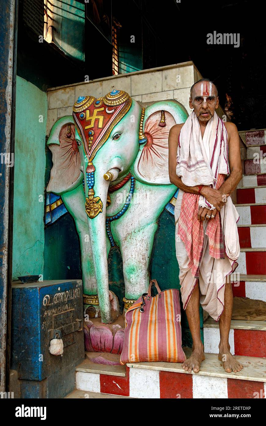 Un homme Vaishnavite debout sur les marches près de l'éléphant en stuc dans le temple Uchi Pillaiyar Kovil à Kumbakonam, Tamil Nadu, Inde, Asie Banque D'Images