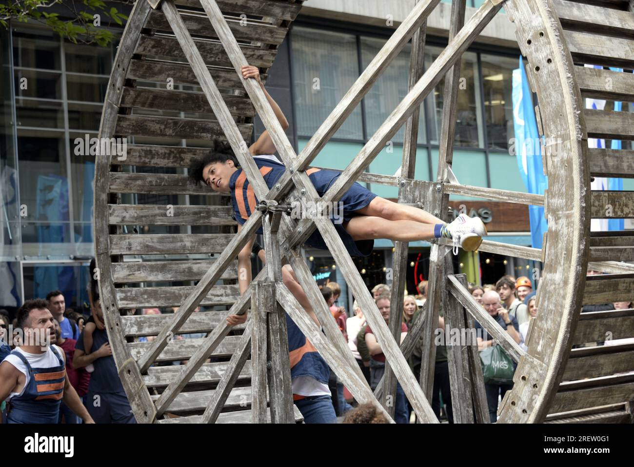 Manchester, Royaume-Uni, 29 juillet 2023. Autin Dance Theatre frappe la physicalité ; mouvement dextre, la roue géante transporte les artistes haut au-dessus des rues, les fait tourner férocement autour. Manchester Day - On Holiday!, gratuit, amusant, familial, événements dans les rues du centre-ville Manchester, Royaume-Uni. Soutenu par Manchester City Council, Manchester Airport Group, Biffa, The Co-op, Manchester Evening News, Walk the Plank, Kingdom of Sweets, British Firefighter Challenge et Capri Beach Club. Crédit : Terry Waller/Alamy Live News Banque D'Images