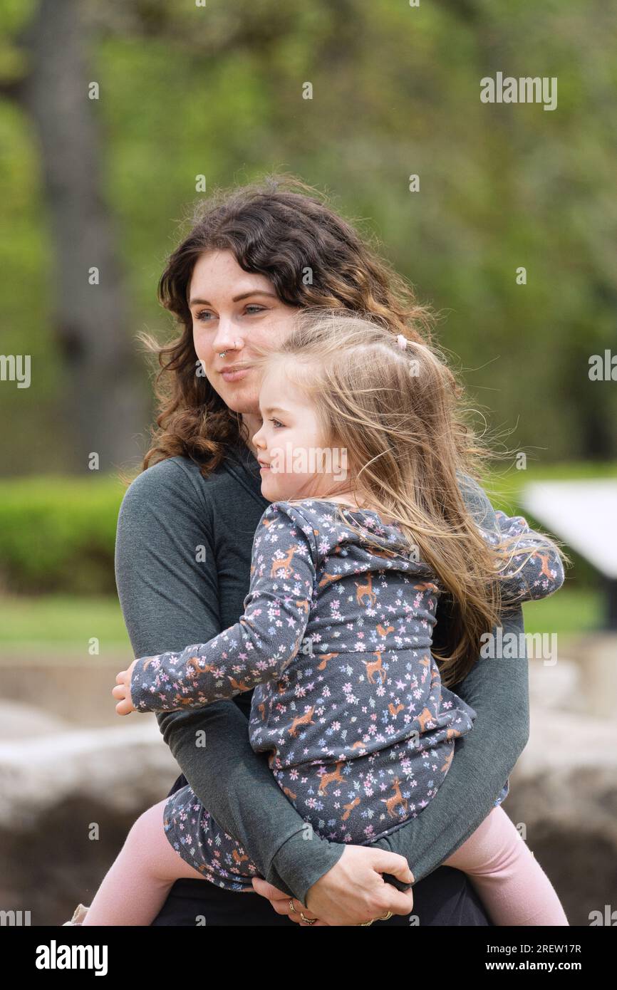 une mère tenant sa fille dans un parc Banque D'Images