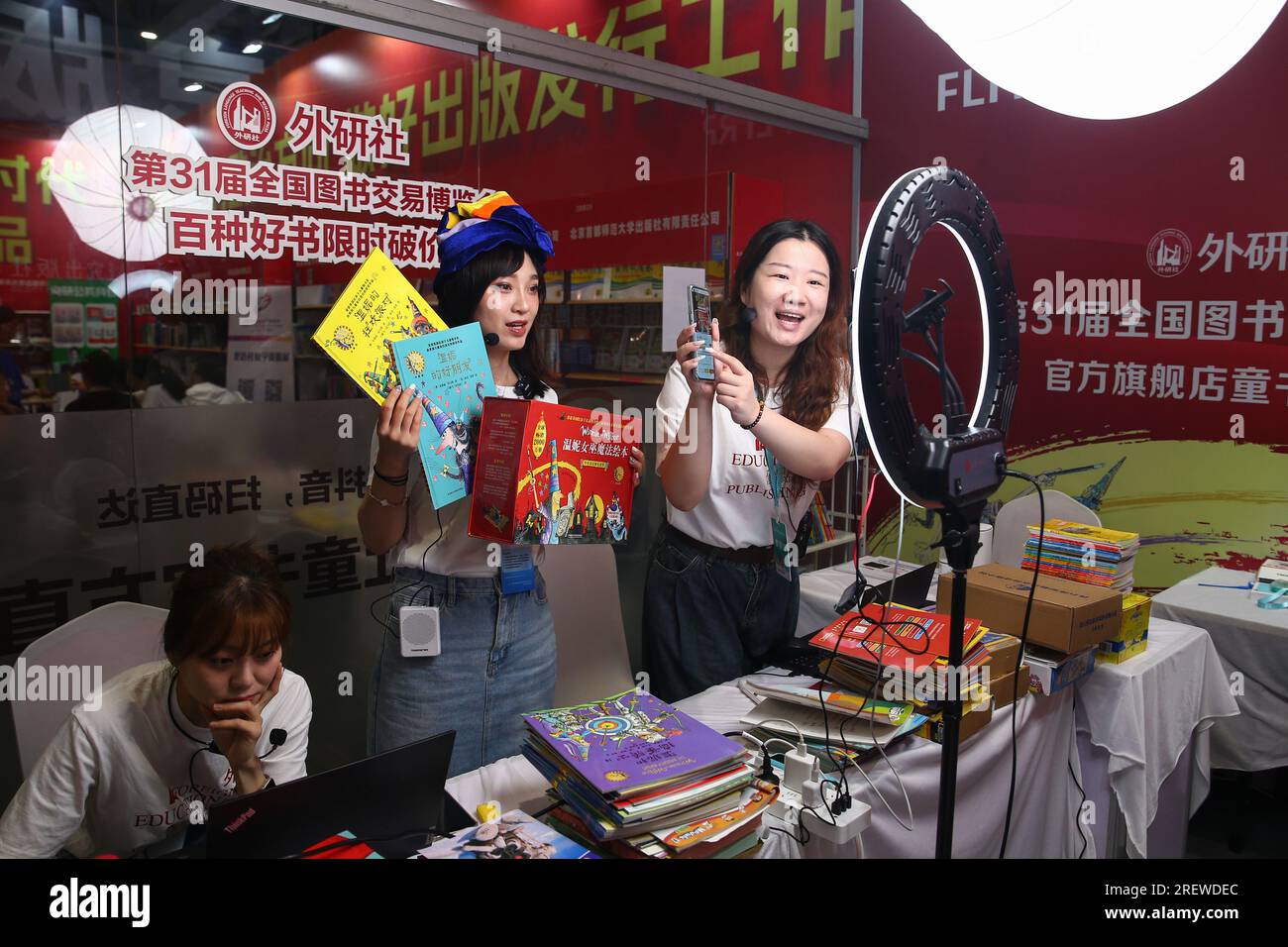 JINAN, CHINE - 30 JUILLET 2023 - Un membre du personnel d'une maison d'édition organise une webdiffusion en direct pour vendre des livres à la 31e Foire nationale du livre à Jina Banque D'Images