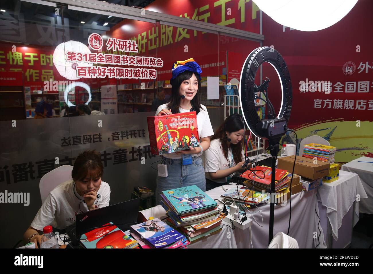 JINAN, CHINE - 30 JUILLET 2023 - Un membre du personnel d'une maison d'édition organise une webdiffusion en direct pour vendre des livres à la 31e Foire nationale du livre à Jina Banque D'Images