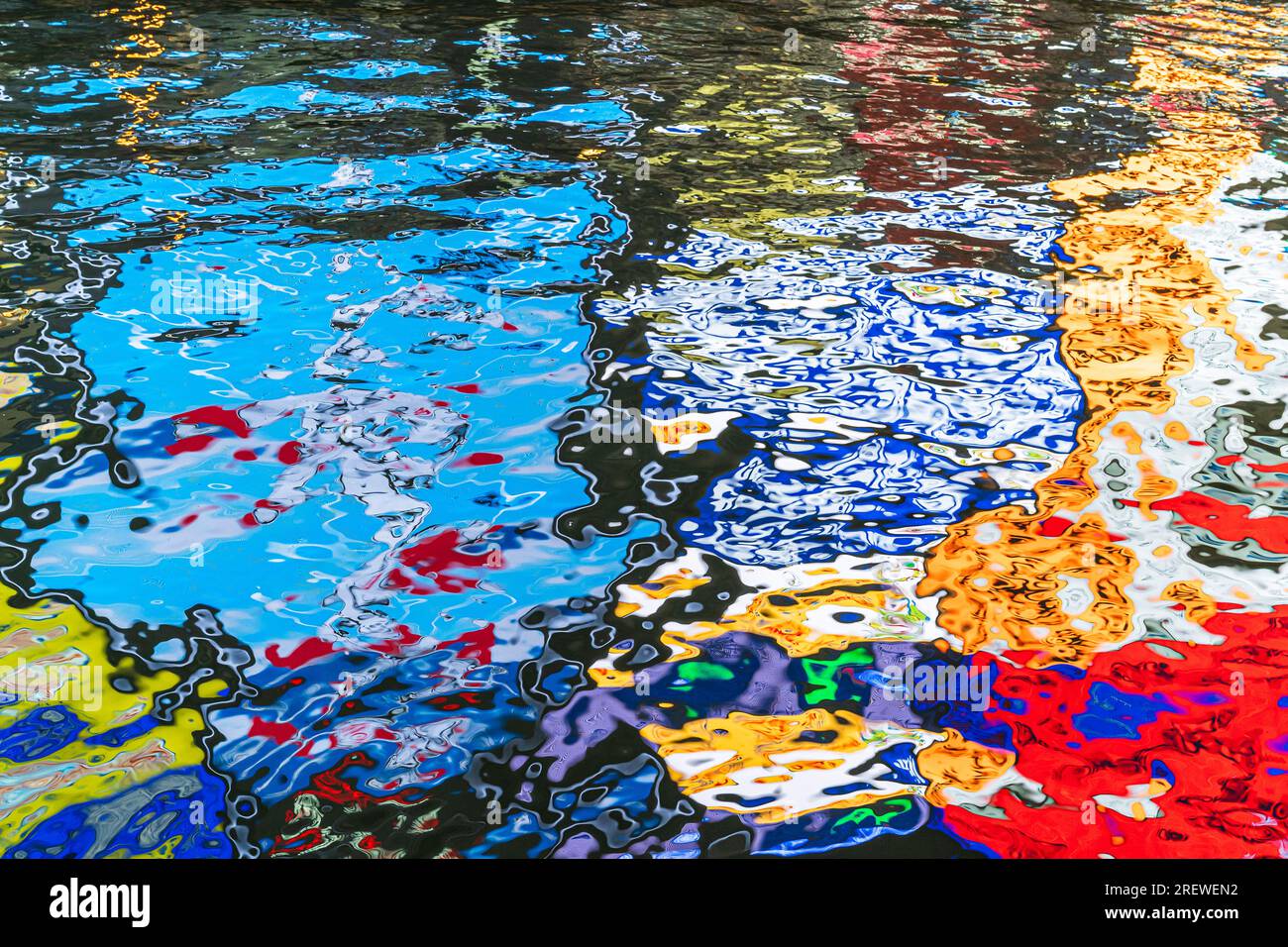 Réflexion nocturne du célèbre signe Glico de l'homme courant dans la rivière Dotonbori, Osaka, fournissant des motifs aléatoires abstraits dans l'eau sombre. Banque D'Images