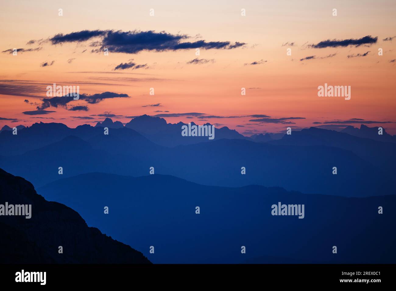 Profils de montagne, silhouettes, couches à l'aube. Ciel rougeâtre. Profils des sommets Dolomites à l'horizon. Alpes italiennes. Europe. Banque D'Images