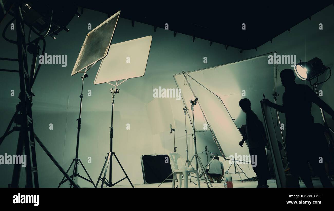 Silhouette de production vidéo en coulisses ou B roll ou réalisation de films publicitaires télévisés que l'équipe de tournage lightman et caméraman travaillent ensemble Banque D'Images