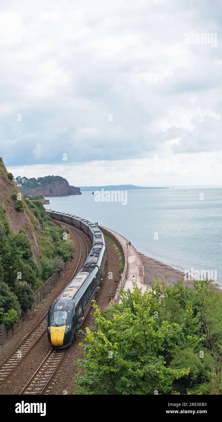 Devon, Angleterre – 21 juillet 2023 : un train de voyageurs Great Western Railway de Londres Paddington sur la route atmosphérique le long de la côte à Teignmouth Banque D'Images