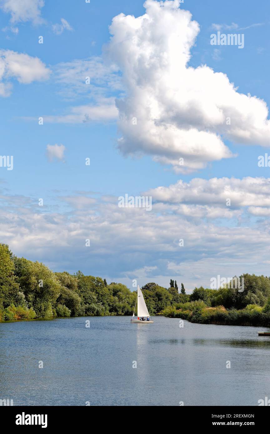 Un petit yacht naviguant sur la Tamise à Shepperton par une journée ensoleillée d'été, Surrey Angleterre Royaume-Uni Banque D'Images