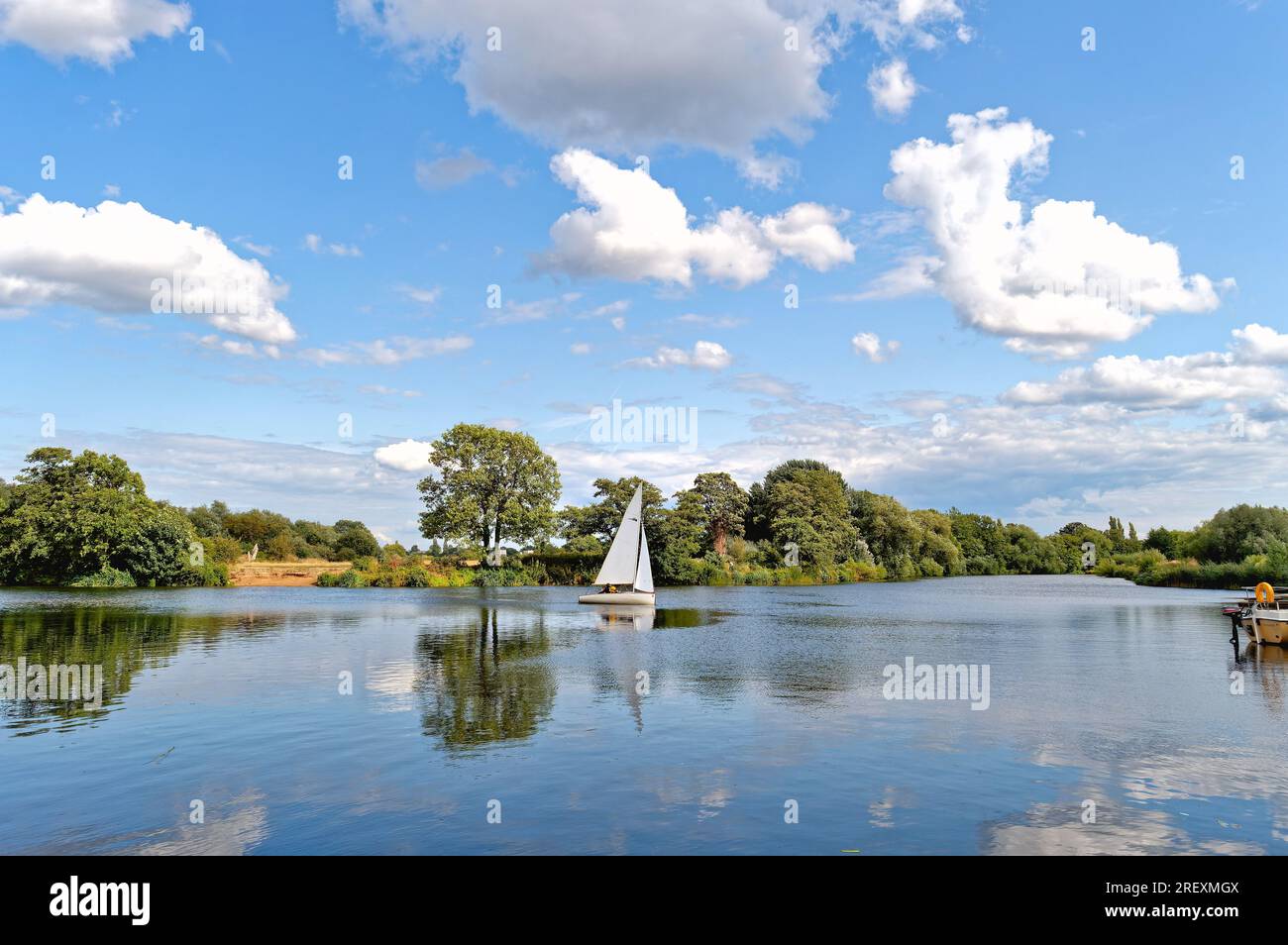 Un petit yacht naviguant sur la Tamise à Shepperton par une journée ensoleillée d'été, Surrey Angleterre Royaume-Uni Banque D'Images