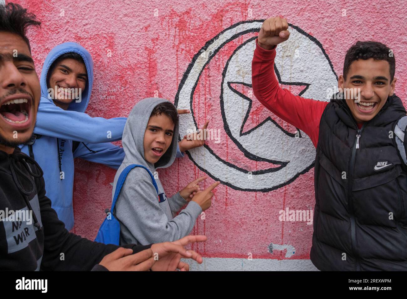 Un groupe d’adolescents devant un mur peint dans un quartier de Sfax, Tunisie Banque D'Images