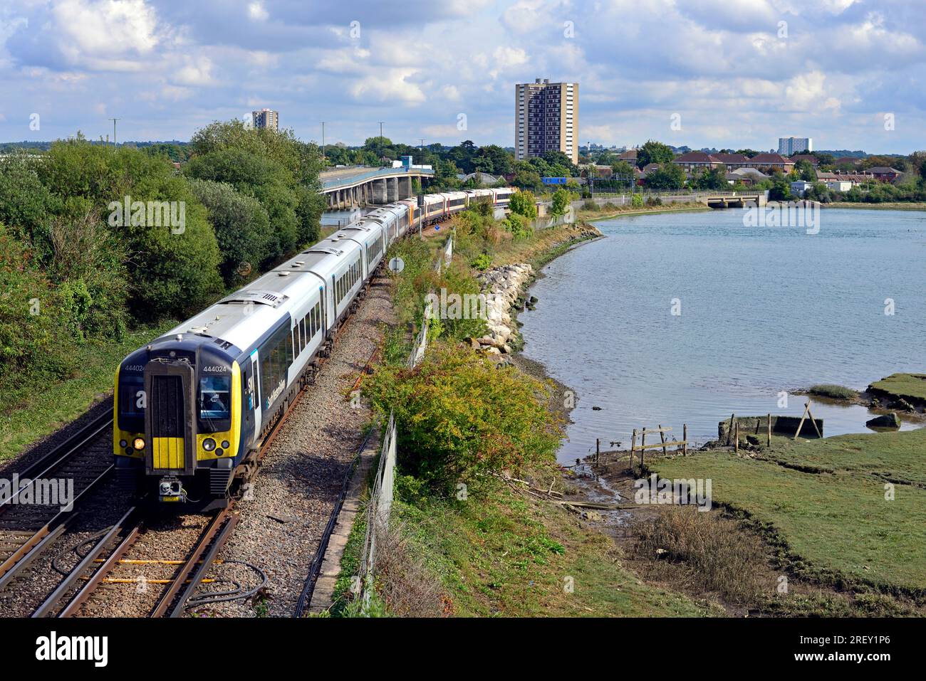 Un train électrique de 10 voitures de London Waterloo à Weymouth traverse Redbridge Causeway. Le River Test entre dans Southampton Water ici. Banque D'Images