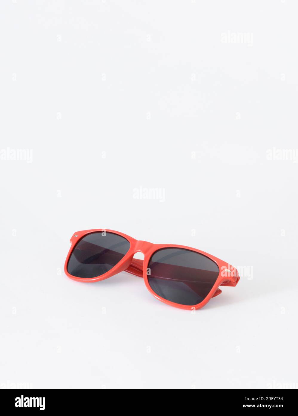 Lunettes de soleil rouges sur fond blanc. Bannière verticale. Espace de copie Banque D'Images