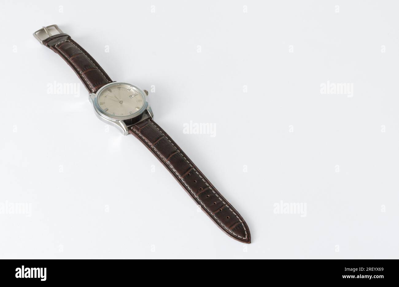 Montre-bracelet dans le style ancien sur un bracelet en cuir. Disposés en diagonale sur un fond blanc isolé. placer pour le texte Banque D'Images