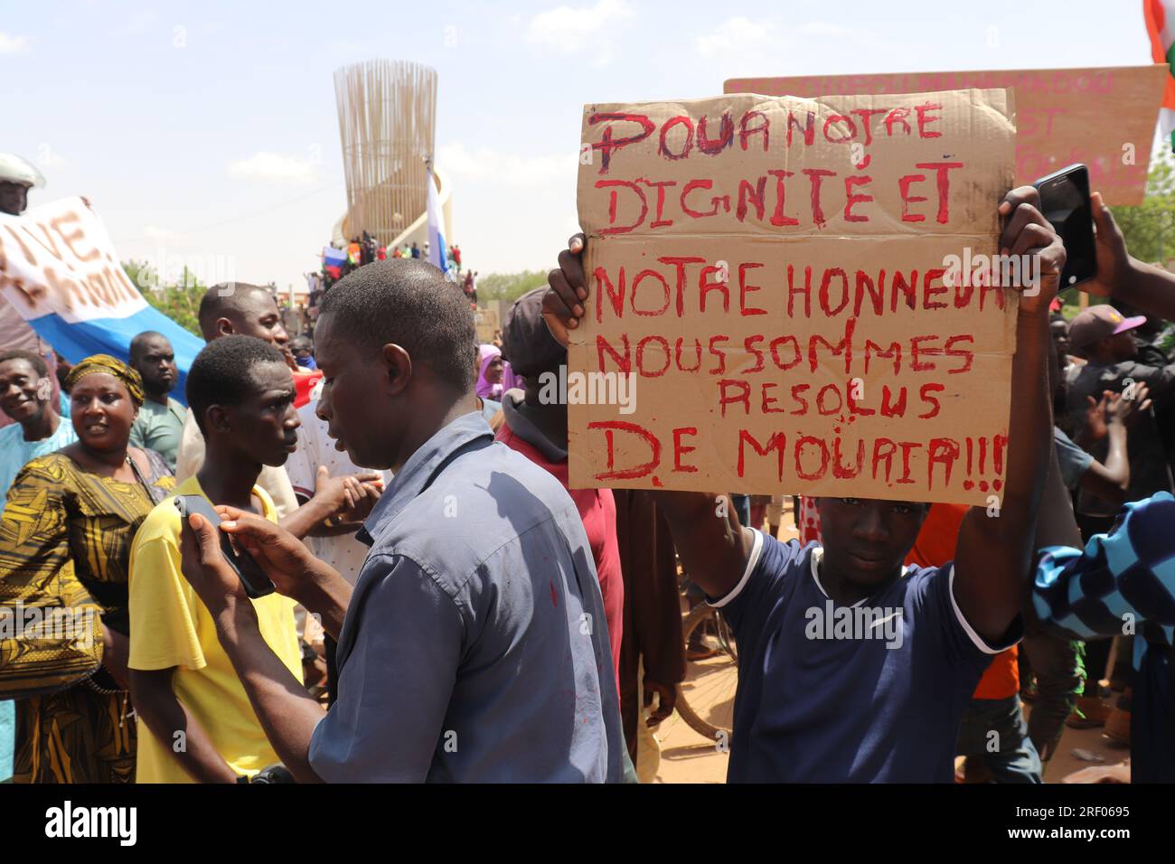 Niamey, Niger. 30 juillet 2023. Les manifestants participent à une marche en soutien aux comploteurs du coup d'État dans la capitale ; à droite, un homme tient une pancarte indiquant "pour notre dignité et notre honneur, nous avons décidé de mourir!!!". Des milliers de personnes s'engagent à soutenir l'armée après le coup d'État au Niger. - Recrop Credit : Djibo Issifou/dpa/Alamy Live News Banque D'Images