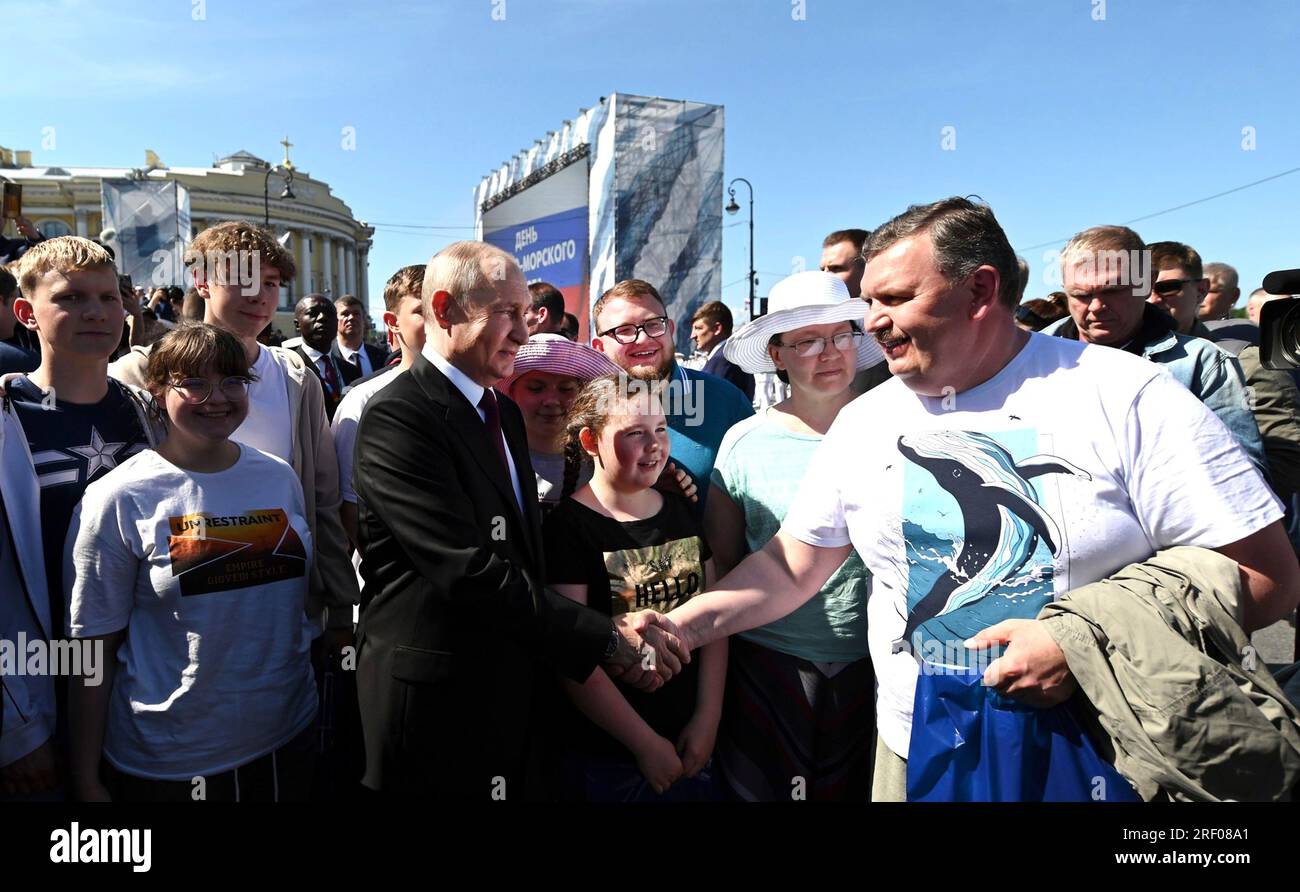 Saint-Pétersbourg, Russie. 30 juillet 2023. Le président russe Vladimir Poutine, au centre, salue Vadim Gorelov, père d'une famille nombreuse de Magadan, qui a reçu l'ordre de la gloire parentale sur la place du Sénat, le 30 juillet 2023 à St. Petersburg, Russie. Crédit : Alexander Kazakov/Kremlin Pool/Alamy Live News Banque D'Images