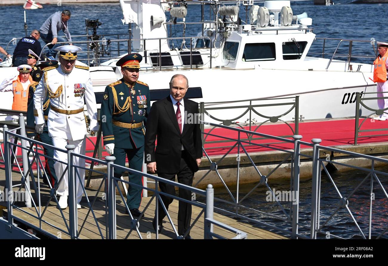 Saint-Pétersbourg, Russie. 30 juillet 2023. Le président russe Vladimir Poutine, à droite, débarque du cutter naval Raptor avec le ministre de la Défense Sergei Shoigu, au centre, et le commandant naval Nikolai Yevmenov, à gauche, lors des célébrations de la Journée de la Marine sur la rivière Neva, le 30 juillet 2023 à St. Petersburg, Russie. Crédit : Alexander Kazakov/Kremlin Pool/Alamy Live News Banque D'Images