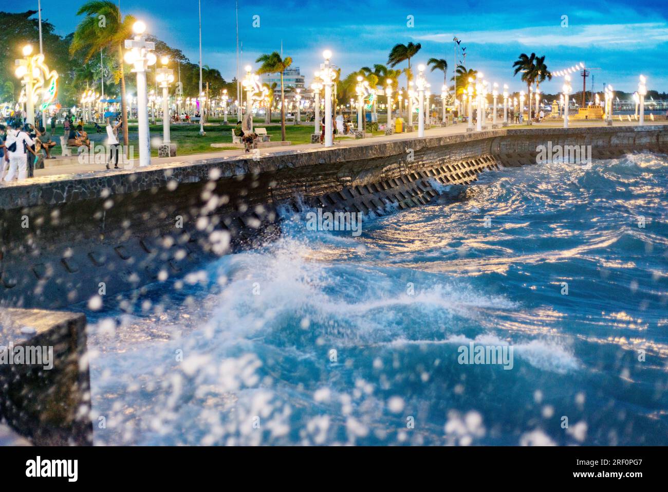 Les mers agitées le long de Rizal promenade piétonne s'étendent, après le coucher du soleil, illuminées par des lampadaires, pendant une soirée Breeze.Popular zone pour les gens de se rassembler i Banque D'Images