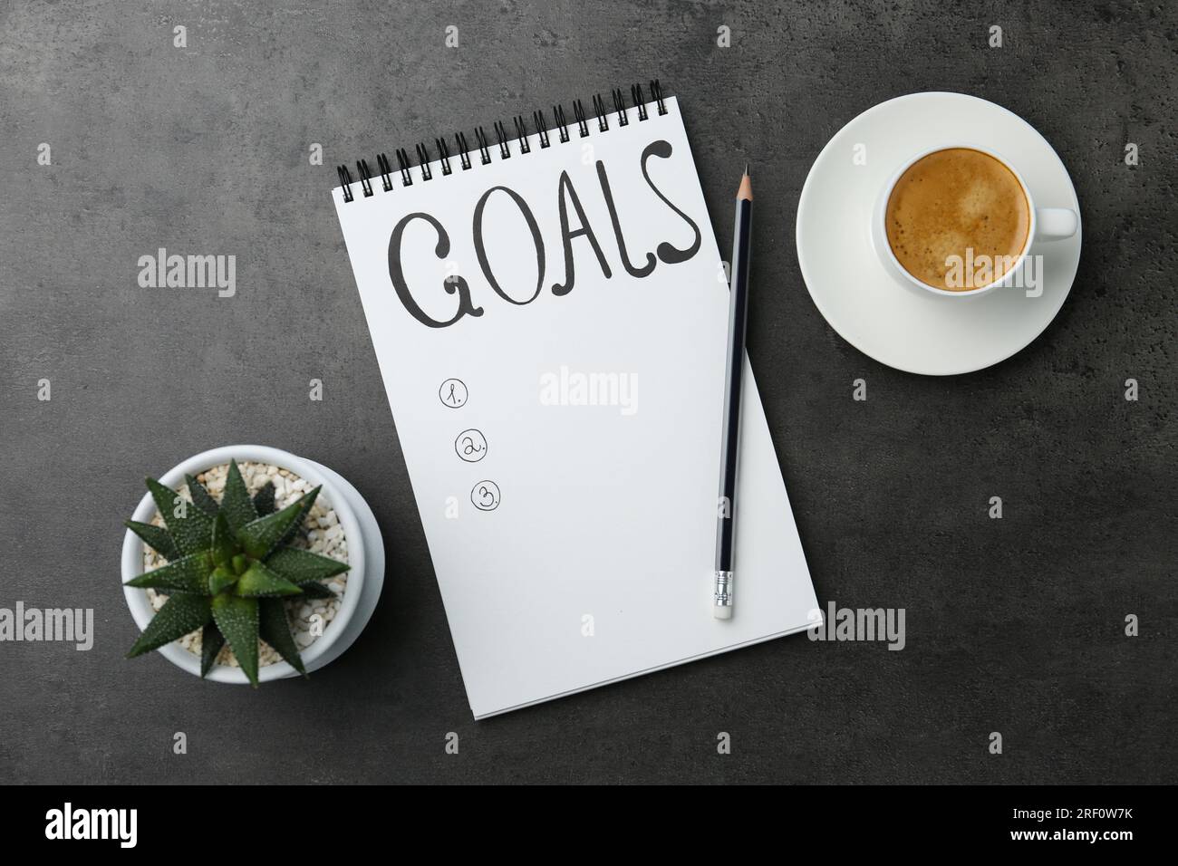 Concept de planification. Liste vide d'objectifs dans le cahier et le café sur fond gris, plat Banque D'Images