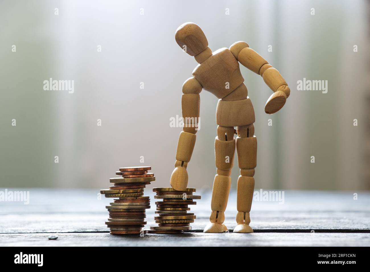 Deux piles de pièces de monnaie et homme en bois sur la table en bois , affaires et financier, économie Banque D'Images